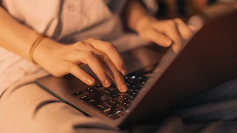 Hands typing on a laptop while editing SEO titles and meta descriptions